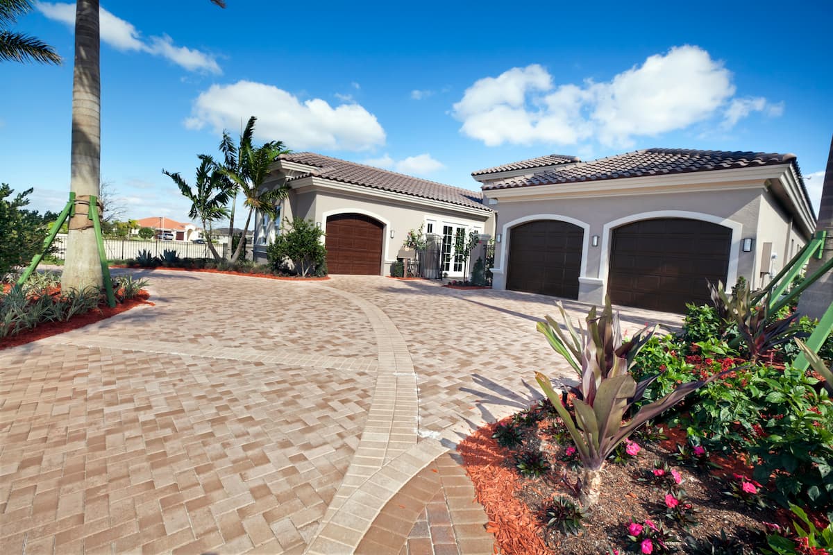 Circular brick paver driveway with tropical landscaping