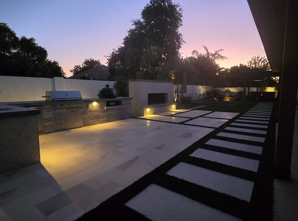 Patio Nocturno con Iluminación Decorativa y Tiras de Césped