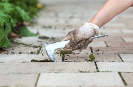 Professional paver repair using pry hammer tool for precise removal and replacement work